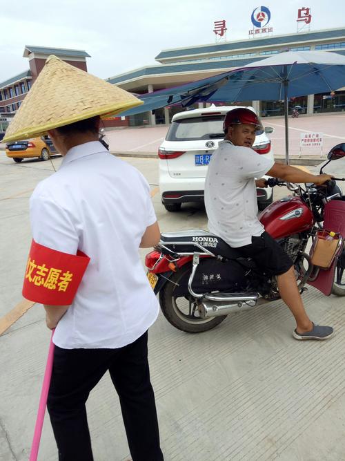 寻乌县汽车站志愿者在网格化责任区范围内劝导出租车摩托车,出租车